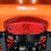 Rear taillight and TMG Industrial logo on orange ATV.
