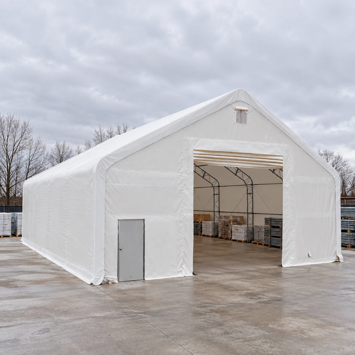 Snow Series 40' x 40' Dual Truss Storage Shelter outdoors on concrete, pallets visible inside