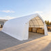 Outdoor installation showing shelter storing lumber pallets, 20' x 40' Arch Wall Peak Ceiling Storage Shelter